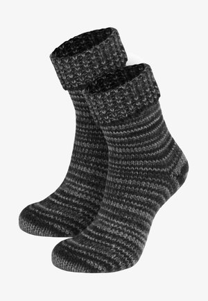 Gestrickte Socken in verschiedenen Grautönen. Dicken Rippbund, gestreiftes Muster und weiche Textur, entworfen für Wärme und Komfort.