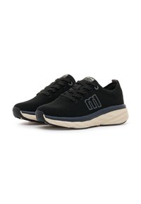 Zapatillas deportivas de malla negra con punta redonda, diseño de cordones, suela acolchada de color crema y acentos de marca en el lado lateral.