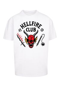 White cotton t-shirt featuring a large red demon skull graphic, black text "HELLFIRE CLUB," and illustrations of weapons in red and black.