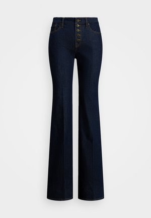 Høytlivede skinnbukser med vidde i mørk denim, fem-knapps glidelås, kontrastfargede gule sømmer og en glatt tekstur.