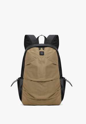 Rugzak met een beige voorkant en zwarte zijkanten, ritssluiting bovenaan en zwarte gevoerde schouderbanden.