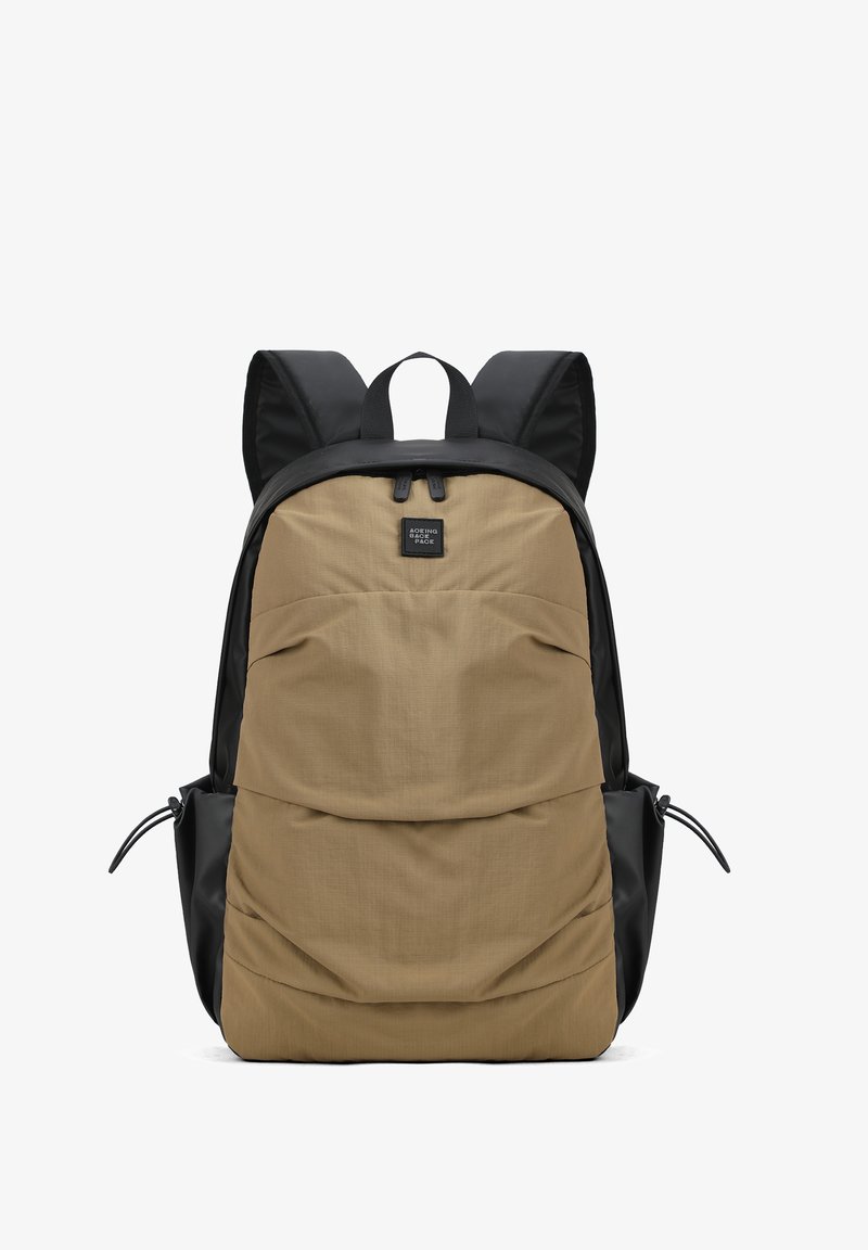 Sac à dos avec panneau avant beige et côtés noirs, fermeture éclair supérieure, et bretelles épaisses rembourrées noires.