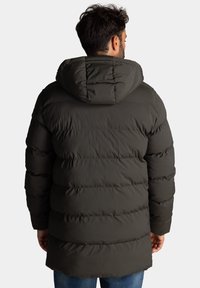 Donkergroen gewatteerde jas met capuchon, met een geborduurd patroon en een lange snit. Zachte buitenste textuur en gevoerde ontwerp voor warmte.