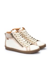 Zapatillas altas de cuero beige con un acabado suave, que cuentan con una cremallera lateral, cordones en la parte frontal y suela de goma.