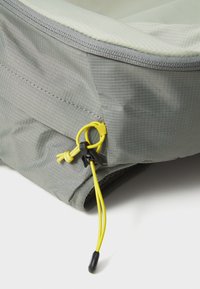 Šedý textilní sáček s texturovaným povrchem, vybavený žlutou šňůrkou se stahováním a lehkým designem. Okraje prošívané pro větší odolnost.