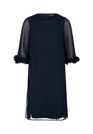 Robe bleu marine avec un col rond, des manches transparentes et des accents froncés aux poignets. Fentes sur les côtés pour plus de facilité de mouvement. Texture de tissu lisse.