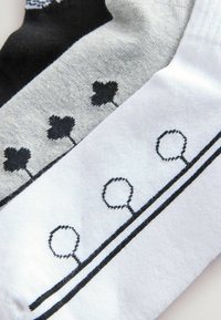 Sosete din bumbac în culorile negru, gri și alb. Inimi negre și modele circulare brodate. Textură moale și elastică, cu manșete ribbate.