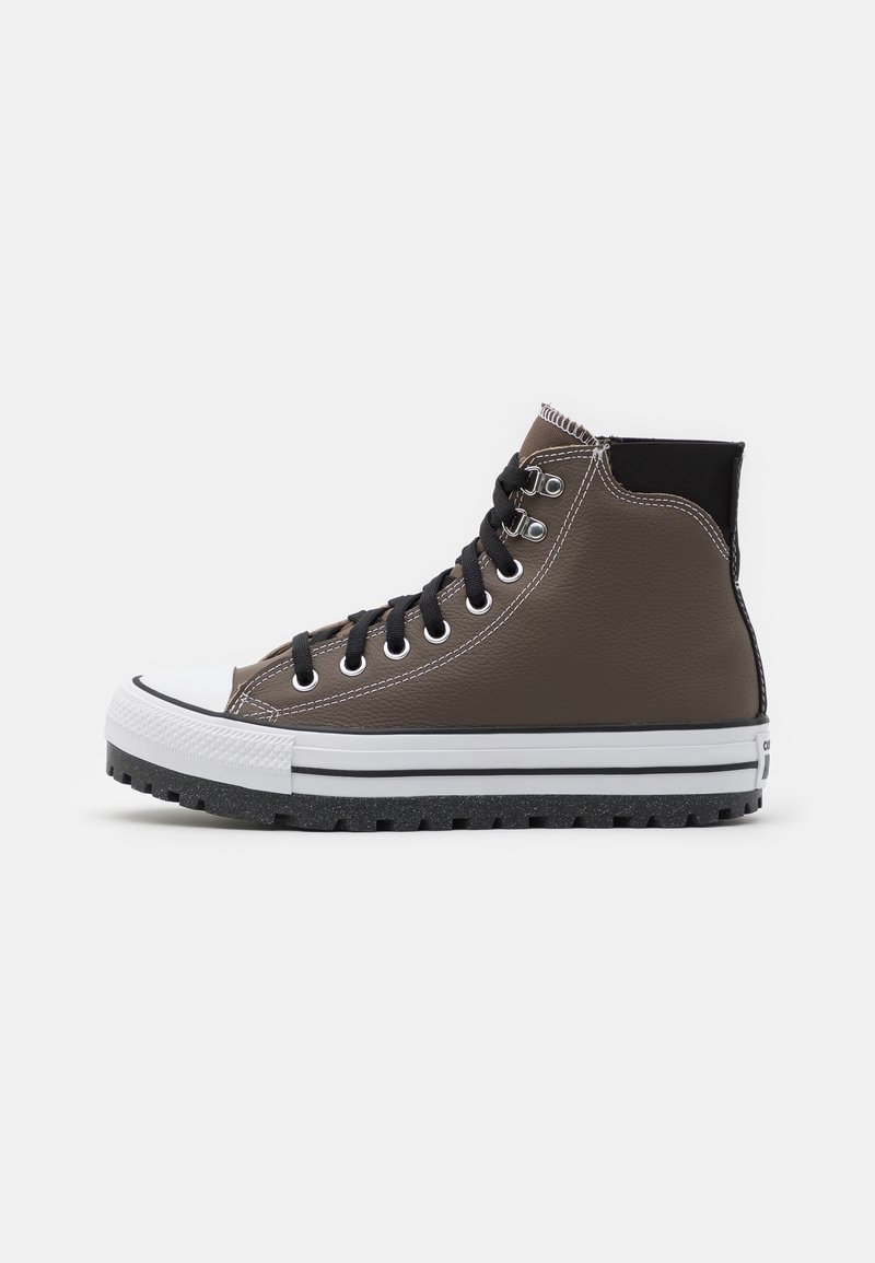Baskets montantes en cuir marron avec lacets noirs, semelle en caoutchouc blanche et semelle extérieure noire, vues de profil sur fond blanc.