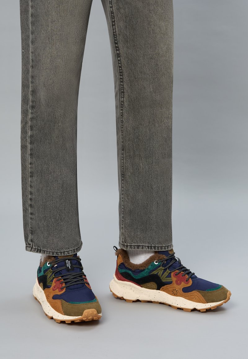 Sneaker multicolori con una combinazione di camoscio e mesh blu, marrone e verde; suola testurizzata e maculata; lacci neri; colletto imbottito.