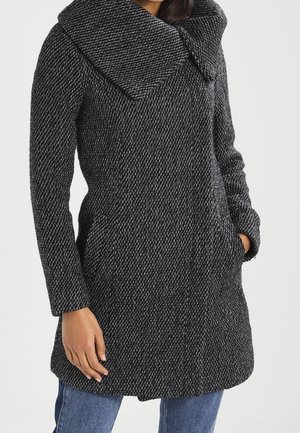 Cappotto grigio e nero a macchie con un grande colletto ampio, due tasche laterali e maniche lunghe, realizzato in un tessuto a trama texturizzata.