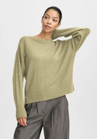 Hellgrüner, gestrickter Pullover mit Rundhalsausschnitt, geripptem Saum und lässiger Passform. Verfügt über lange Ärmel mit einem abgesenkten Schulterdesign.