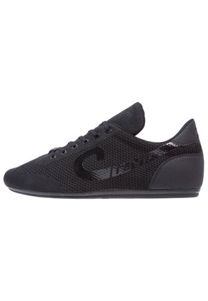 Low-profile zwarte sneaker met mesh bovenwerk, zwarte veters en subtiel merkdetail langs de zijkant en hiel, zij-aanzicht.