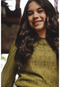 Olivengroen gebreide trui met een textuurpatroon van verticale lijnen en bladvormige motieven. Lange mouwen en ronde hals zichtbaar.