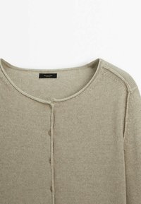 Cardigan lavorato a maglia beige con scollatura rotonda, chiusura frontale con bottoni e dettagli di cucitura delicati lungo i bordi.
