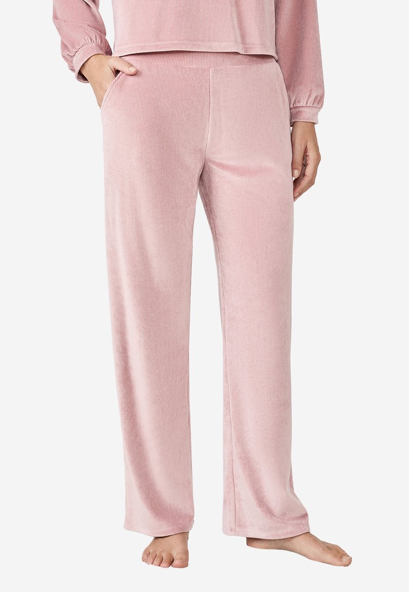 Różowe, miękkie spodnie dresowe z korduroju o luźnym kroju, szerokich nogawkach i kieszeniach. Gładka tekstura z pionowym wzorem żebrowanym.