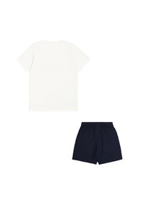 Maglietta in cotone color avorio con maniche corte abbinata a pantaloni corti blu navy con vita elastica. Design semplice, texture morbida, outfit informale.