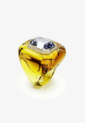 Un anello giallo massiccio presenta una grande pietra trasparente ottagonale circondata da piccole gemme brillanti, su uno sfondo bianco.