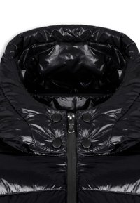 Giacca a vento nera con colletto alto, texture lucida, zip centrale e dettagli decorativi con bottoni sul davanti.