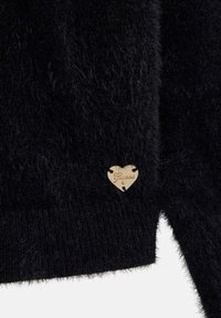 Must musta, millel on südame kuju silt, millel on graveeritud sõna "Guess" ja mille keskosas on väike teemanditaoline detail.