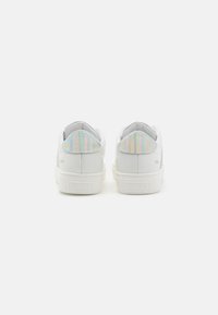 Sneakers bianchi in pelle con una superficie liscia, dotati di un accento iridescente sul tallone e un logo impresso sul retro.