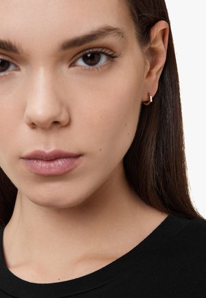 Gold-tone geometric hoop earring with a sleek design. Minimalist style, featuring a polished finish and a subtle accent at the hinge.