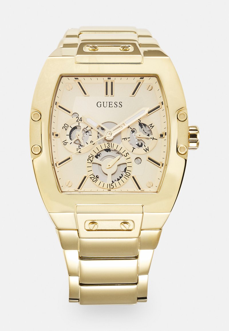 Gullfarget Guess-klokke med rektangulært klokkeansikt, beige urskive, kronograf underdials og en kraftig metallarmbånd. Har markante timemarkører.