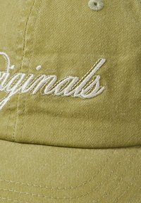 Olivenfarvet baseballcap med tekstureret stof, der har hvid broderet "originals" tekst. Indeholder syede detaljer og en knap på toppen.