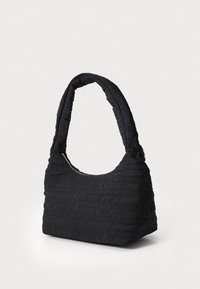 Sac à main noir matelassé avec une bandoulière arrondie, présentant un tissu texturé avec un subtil logo et une fermeture éclair.