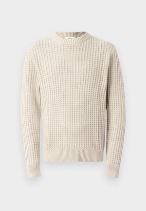 Teksturert kremfarget genser med ribbede mansjetter og halslinning. Har et rutemønster over hele. Passer godt til lag-på-lag styling.