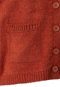 Roter Strickcardigan mit einem strukturierten Design, einer aufgesetzten Tasche und braunen Knöpfen entlang der Vorderseite.