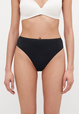 High-waisted black bikini briefs featuring a smooth texture and a subtle Calvin Klein logo on the waistband.