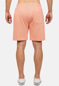 Pantaloni corti da uomo color pesca con vita elastica, tasca posteriore e taglio dritto. Realizzati in tessuto morbido e leggero.