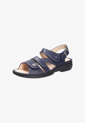 Sandale en cuir bleu marine avec bout ouvert, plusieurs sangles réglables et semelle texturée. Présente un accent décoratif en métal.