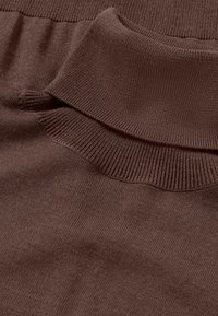 Pull en tricot marron avec un col et des poignets côtelés, offrant une texture lisse et un tissu doux, affichant un motif continu.