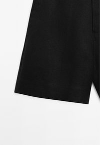 Short en tissu noir avec un ourlet droit, présenté depuis la zone du genou sur fond blanc.