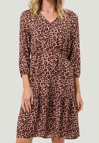 Robe à imprimé léopard dans des tons beige et marron, présentant un col en V, des manches trois-quarts et une jupe à volants froncée.