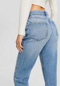 Jeans azzurri a vita alta con vestibilità rilassata, caratterizzati da tasche posteriori cucite e una leggera scoloritura su tutta la stoffa.