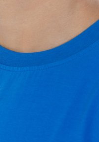 Camiseta de manga corta azul hecha de algodón suave. Presenta un escote redondeado y un diseño simple con una textura lisa.