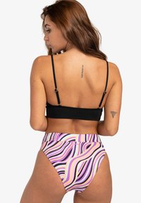 Černý bikiny top s nastavovacími ramínky, doplněný vysokými kalhotkami s vlnkovými vzory v purpurové, růžové a černé barvě.