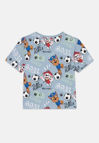 Īsām piedurkņu gaiši zila kokvilnas T-kreklu ar karikatūrām suņiem, futbolbumbām un tekstu "TEAM PLAYER" un "GOAL" dažādās krāsās.