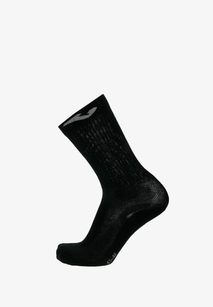 Calza sportiva nera con una texture a coste e un logo bianco sul bordo. Il design è di lunghezza media fino al polpaccio, con aree rinforzate sulla punta e sul tallone.