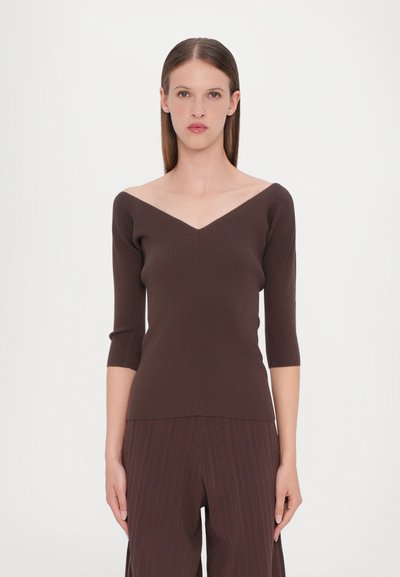 Haut en maille côtelée marron avec un décolleté en V large et des manches trois-quarts, présentant une silhouette ajustée et une texture lisse.