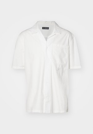 Chemise blanche à manches courtes en mélange de coton, avec un col pointu, une poche avant et un discret accent brodé sur le côté gauche.