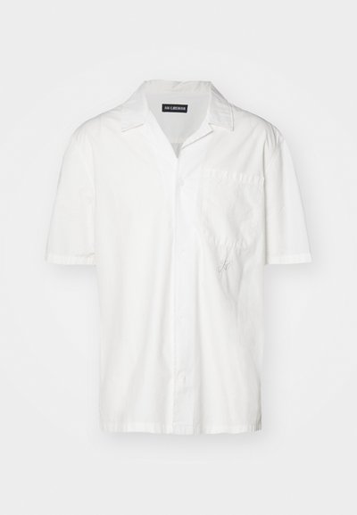 Lühikeste varrukatega valge särk puuvilla segust, millel on terav krae, eesmine tasku ja peenelt broderi rõhutus vasakul poolel.