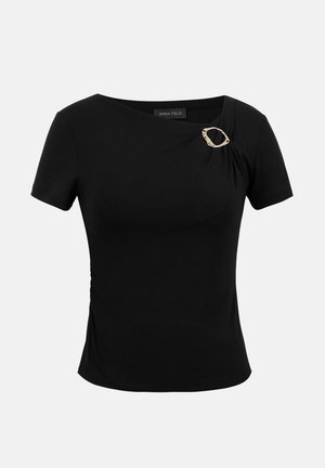 Melns krekls ar īsām piedurknēm, apaļu kakla izgriezumu, savāktu detalizējumu un mazu zelta krāsas sprādzi uz kreisā pleca.