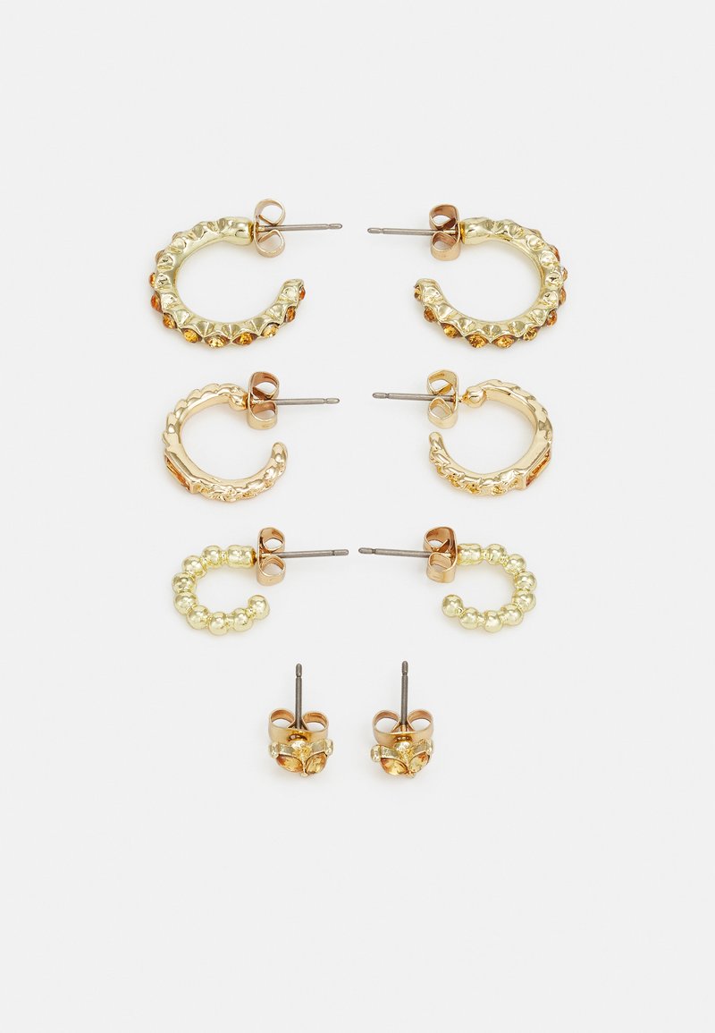 Zelta tonētas auskaru komplekts: divi gredzenu auskaru pāri ar teksturētām dizainiem un rhinestones, un divi pāri pieskrejamajiem auskariem ar apaļiem akcentiem.