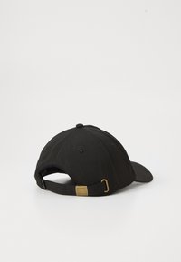 Svart baseballcaps med en lett buet skjerm, tekstur av stoff og en justerbar stropp med en gullfarget metallspenne.