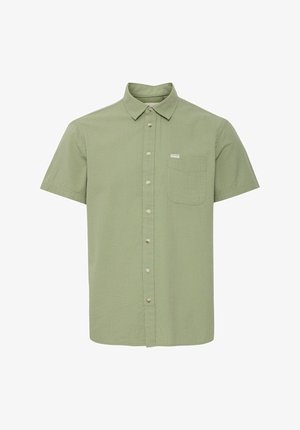Chemise à manches courtes avec boutons en tissu texturé vert clair. Comprend une poche poitrine et une petite étiquette logo près de la poche.