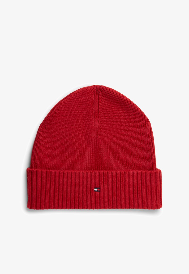 Bonnet en tricot rouge avec bord côtelé retourné et petit patch logo rectangulaire blanc, marine et rouge au centre avant du bord.