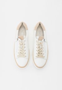 Baskets en cuir blanc avec des accents en suède beige, des lacets texturés beiges et un détail de fermeture éclair sur le côté. Semelle en caoutchouc avec un bord tissé.